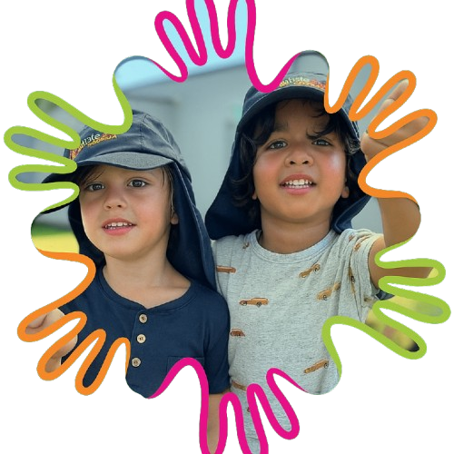 Two children smiling outdoors wearing sun hats decorated with colorful frames.
