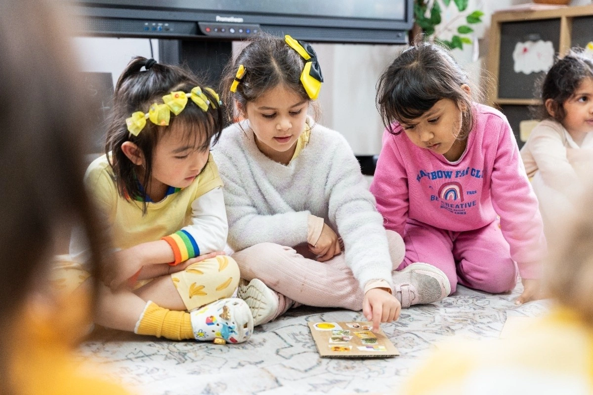 School-age children sitting on the floor engaged in a group activity.